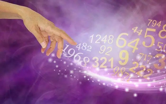 Female hand appearing to create a swish of sparkles and a flow of random numbers on a pink purple energy formation background