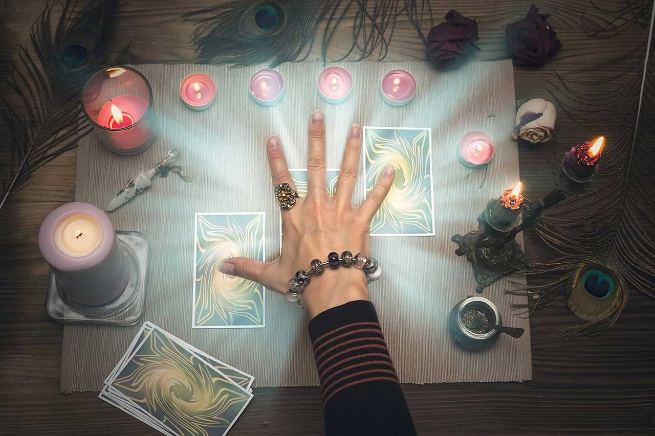 A psychic reader surrounded by tarot cards and candles