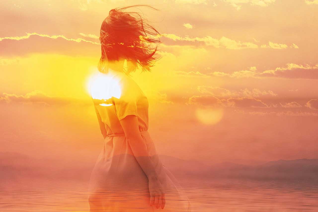 Double exposure of young woman and sunset sky