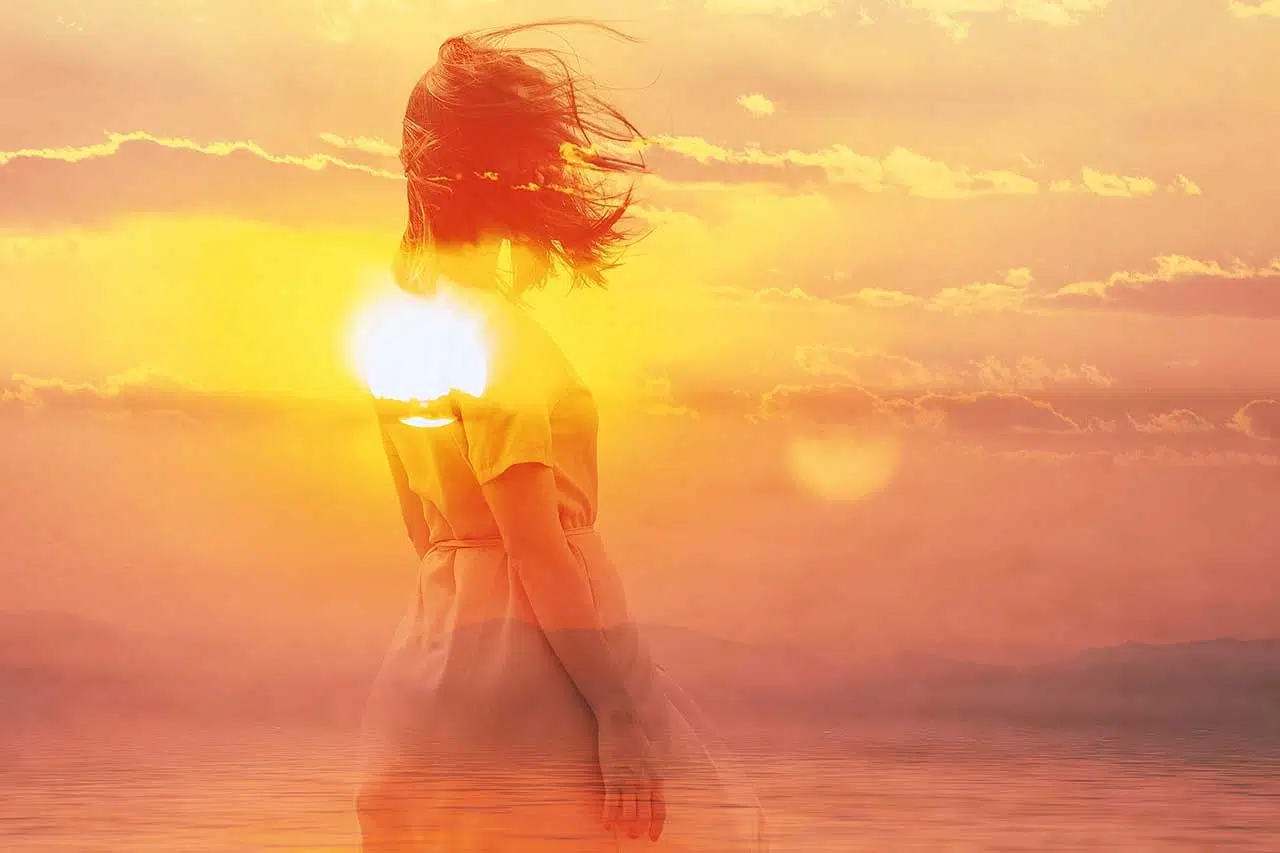 Double exposure of young woman and sunset sky