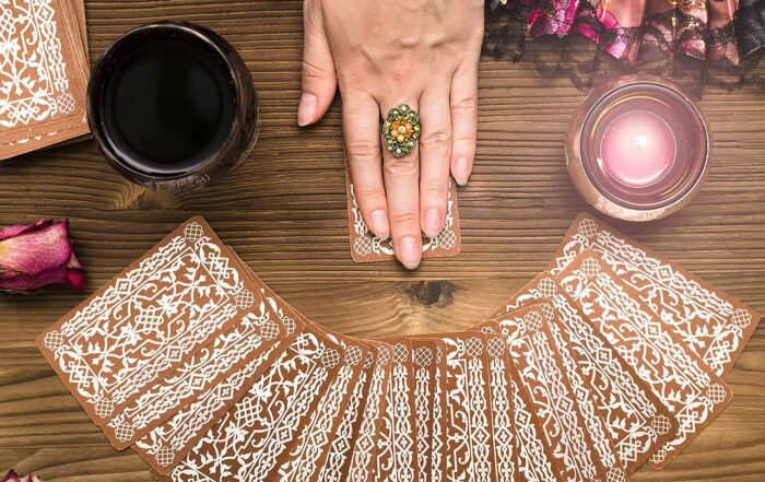 Fortune teller female hands and tarot cards on wooden table. Divination concept.