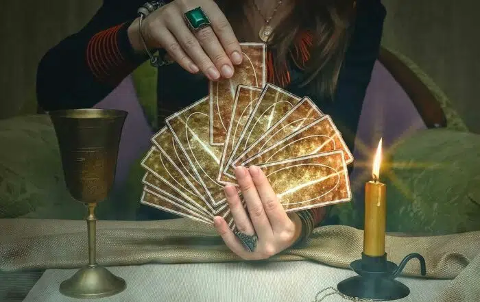 Woman fortune teller holding a deck of tarot cards.
